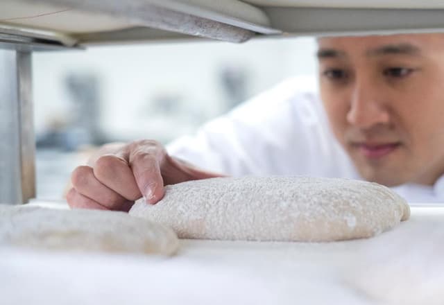 A baker preparing bread dough