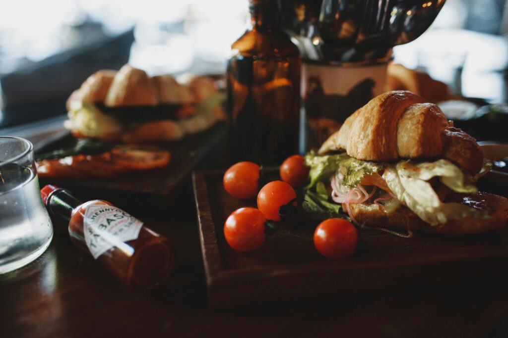 pexels-photo-4552173-4552173 Fresh croissant sandwich with lettuce and tomatoes on a wooden board, perfect breakfast idea.